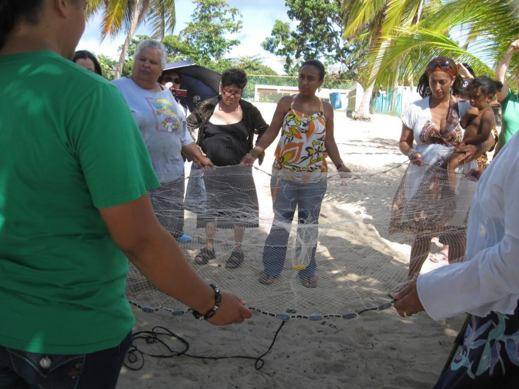 Figure 10. FORJANDO REDES HACIA LA DESMILITARIZACIÓN Y LA SECURIDAD GENUINA /
FORGING NETS FOR DEMILITARIZATION AND GENUINE SECURITY
2012 8th Network meeting in Puerto Rico. Ceremony at the beach, Vieques, with fishing net. Design: Maria Reinat Pumarejo and Vieques Women’s Alliance