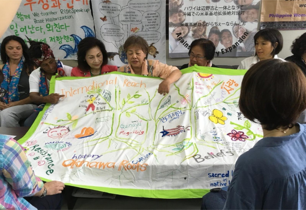 Figure 12. OKINAWA ROOTS, INTERNATIONAL REACH
Banner made by Network members at the 2017 meeting to thank Okinawa women, the hosts, and to recognize their long-standing, far-reaching activism. Fabric markers on cotton cloth.